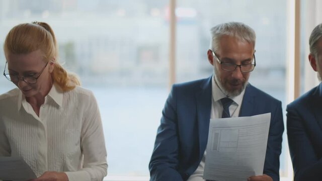 Business people waiting in queue and preparing for job interview reading cv