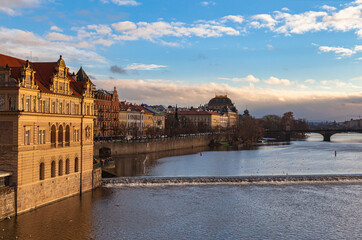 Beautiful view of Vltava river side with Bedřich Smetana Museum, National Theatre and Legion Bridge from Charles Bridge on sunny winter day with blue sky cloud, Prague,  Czech Republic