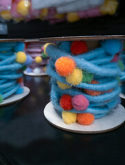 blurry decorative fluffy colored threads with multicolored balls close up


