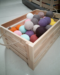 Christmas decor in a wooden box. Multicolored balls of thread in shop