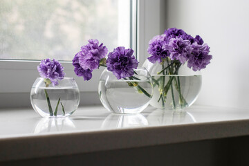 Bridal bouquet of lilac carnations in a round glass vase