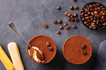 Tiramisu dessert in glasses. Dark grey background. Top view.