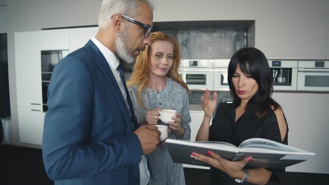 Kitchen saleswoman going through ideas with potential buyer couple