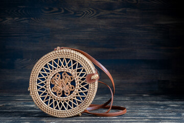 Modern stylish round straw bag on the wooden background