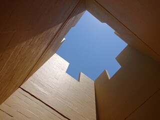 Looking up from an open interior of modernism geometric architecture pavilion in a rural area