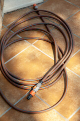 Brown flexible hose lies on  tile