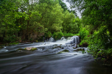 Beautiful waterfall in an abandoned forest on a summer day.