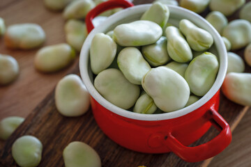 broad bean. Healthy eating. Red pot on a wooden table.
