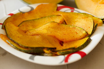 A plate of baked pumpkin pieces on the plate. Sweet quick snack