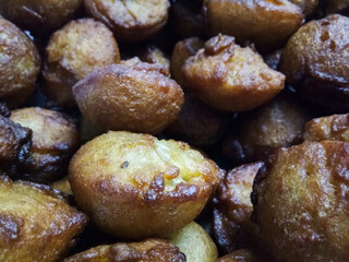 Kerala traditional style soft puffy sweet unni appam placed in a steel plate after being fried in hot boiled coconut oil 