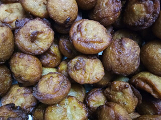 Kerala traditional style soft puffy sweet unni appam placed in a steel plate after being fried in hot boiled coconut oil 