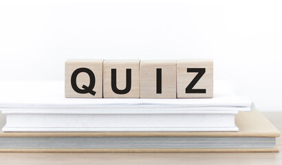 Quiz sign on wooden cubes lying on a stack of books
