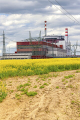 Fototapeta na wymiar Reactor of nuclear power plant Temelin with field of rape in Czech Republic. Cloudy sky.