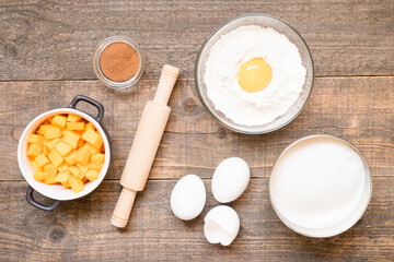 Top view raw ingredients for cooking pumpkin pie on wooden background. Bakery background.