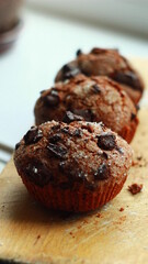 chocolate muffins with pieces of chocolate on the wooden boards