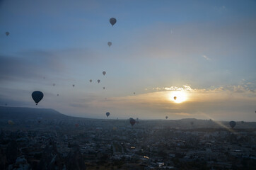 Colorful hot air balloons flying over mountains landscape and the valley at Cappadocia in the sunrise sky at foggy morning