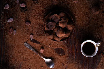 healthy delicious chocolate truffles around ingridients with natural cocoa beans,  powder, cacao butter, cane sugar and cup of coffee. healthy sweets concept. flat lay
