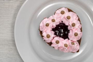 Obraz na płótnie Canvas Heart-shaped cake. Cake on a white saucer.