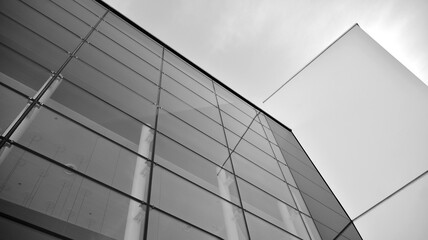 Fototapeta na wymiar Modern office building wall made of steel and glass with blue sky. Black and white.