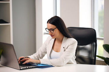 Focused woman working at her computer. Background for office startup