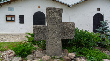 Pskov, Russia. Ancient cross near the temple and the Pokrovskaya tower