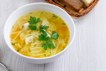 Bowl of chicken soup with vegetables and noodles. Selective focus.