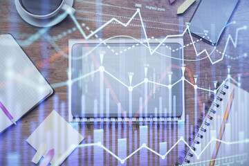 Double exposure of forex chart hologram over desktop with phone. Top view. Mobile trade platform concept.