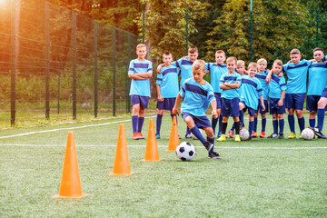 Kids running and kicking soccer balls on children football training session © Serhii