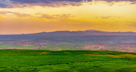 beautiful sunset over the mountains and greenfield