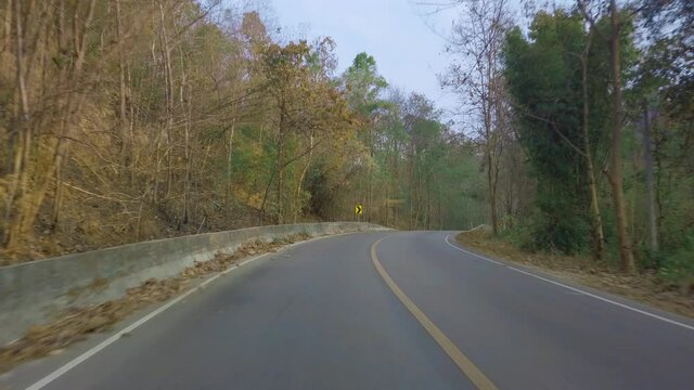 Driving along a mountine road in national park in Thailand. Point of view driving. View from inside the car, motobike POV driving footage 4K