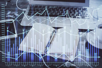 Multi exposure of financial graph drawings and desk with open notebook background. Concept of forex