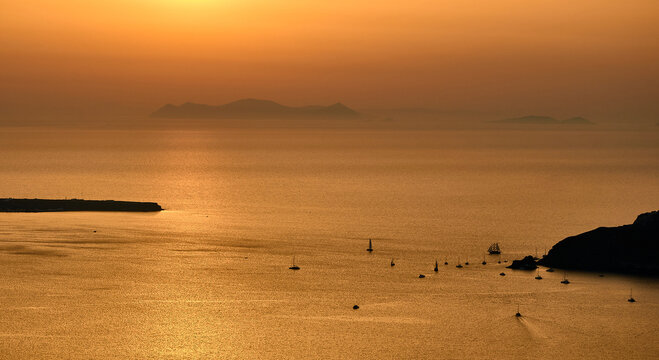 Sailing boats at Santorini caldera in the sunset