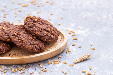 Stack of tasty cocoa cookies with wheat and peanut on rustic table, handmade or prepared snack food