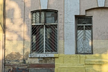 Obraz premium two old windows with a lattice on a brown concrete wall