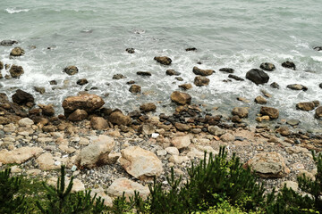 A Rocky Coastline with a Calm Sea on on Overcast Day