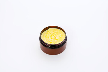 Black jar with yellow cream with sea buckthorn oil on a white background.