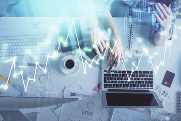 Double exposure of man and woman working together and financial graph hologram drawing. market analysis concept. Computer background. Top View.