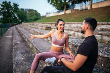 Man and woman sitting together on empty sports tribune and talk.