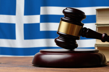 Justice and court concept in Greece. Judge hammer on a flag background