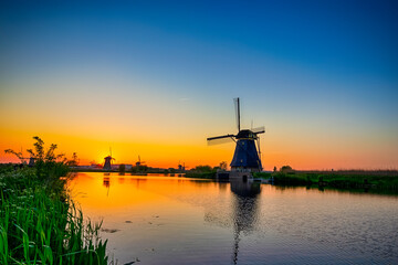 Fototapeta na wymiar Traditional Romantic Dutch Windmills in Kinderdijk Village in the Netherlands During Golden Hour.