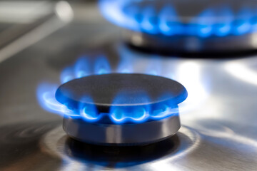 Gas Oven Concepts. Macro Shoot of Two Gas Burners on Stove Surface with Flames.