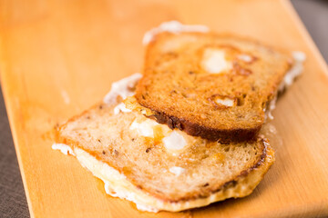 Slices of Traditional Fried Bread With Eggs. Placed Over Wooden Board Indoors.