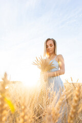 woman in wheat field at sunset