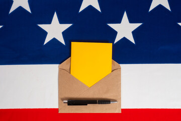 Open envelope on background of flag of America. Remote elections in US. Concept - there is a ballot paper in envelope. Elections of President of US. Absentee voting in USA. Voting US Postal Service