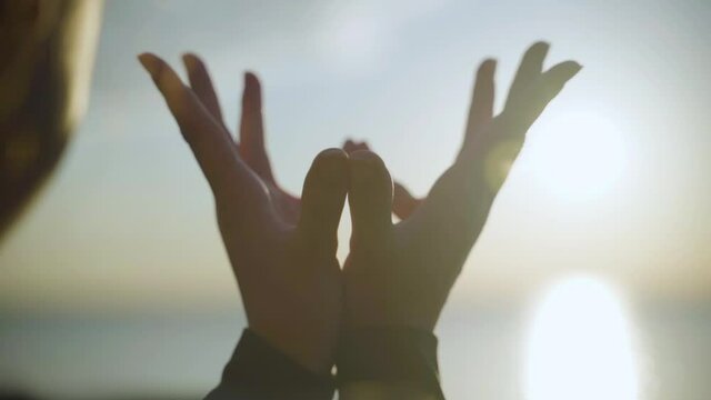 Woman's hands in Padma Mudra at sunrise. Slow motion.