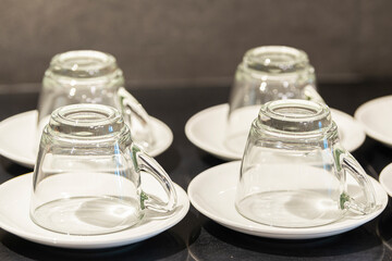 Many rows of Glass cup on ceramic plate for tea or coffee in restaurant or hotel.