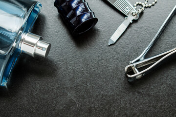 Fototapeta na wymiar Metal nail clipper and men beauty tools on a black wooden table