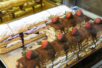 Huge blueberry cream pie dessert and chocolate pie with strawberry on top inside a transparent container
