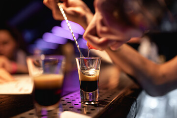 The barman makes drinks for the guests. Nightlife, club life. Spectacular serving of cocktails. Stunning cocktails.