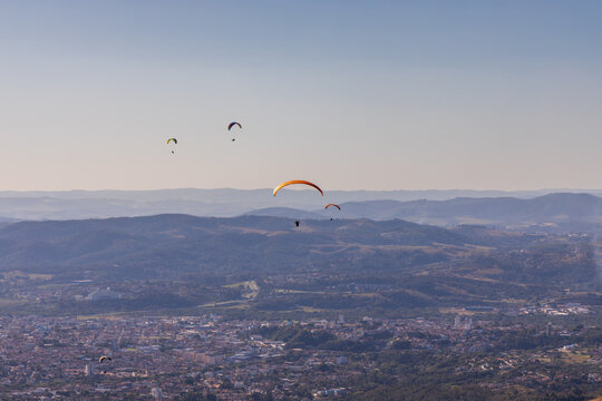 Pessoas praticando voo de parapente. Esporte radical. Descendo pelas Montanhas de paraquedas. Sensa&ccedil;&atilde;o de liberdade. 